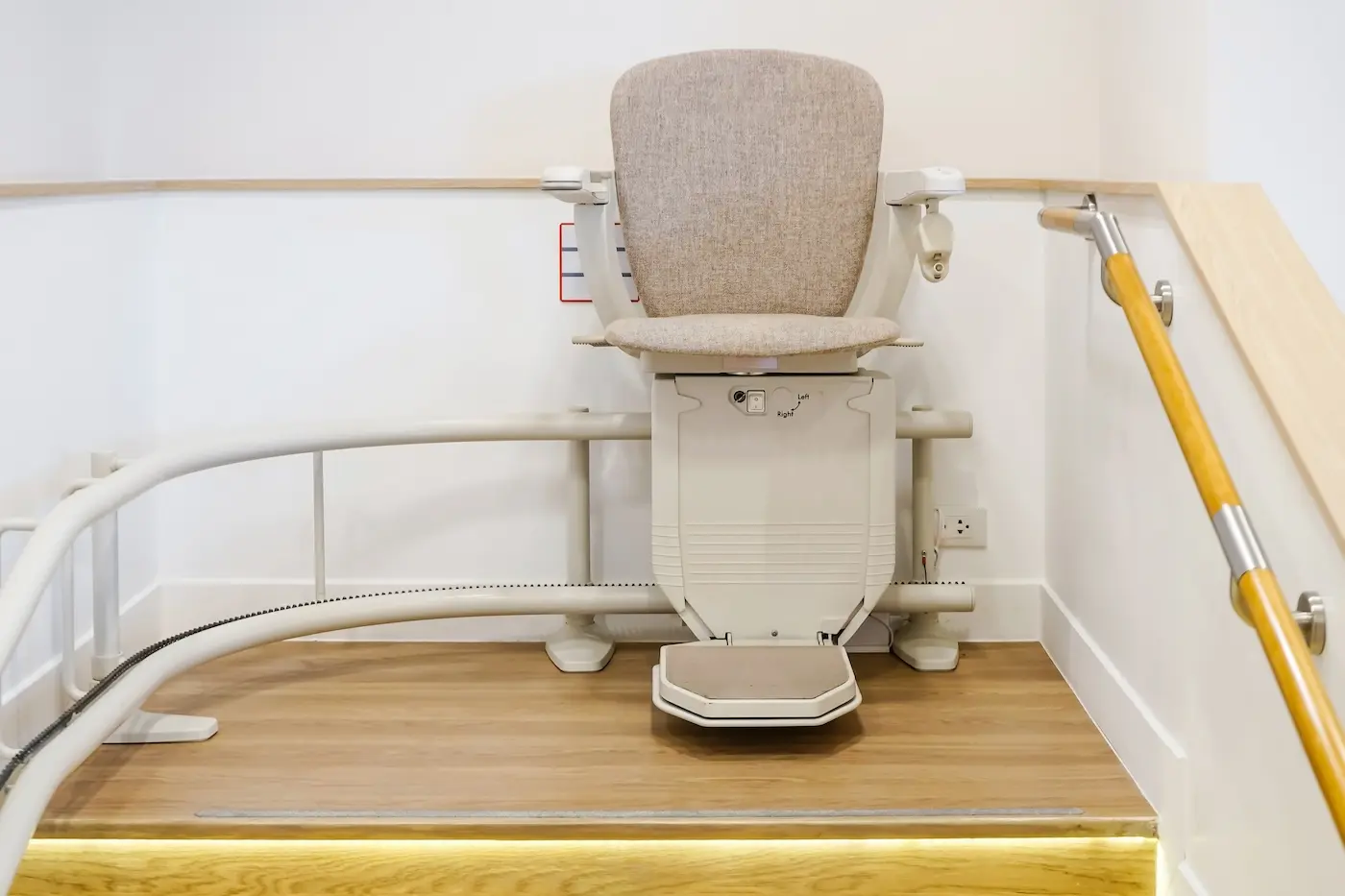 Detalle del asiento, el reposabrazos y el mando de una silla salvaescaleras