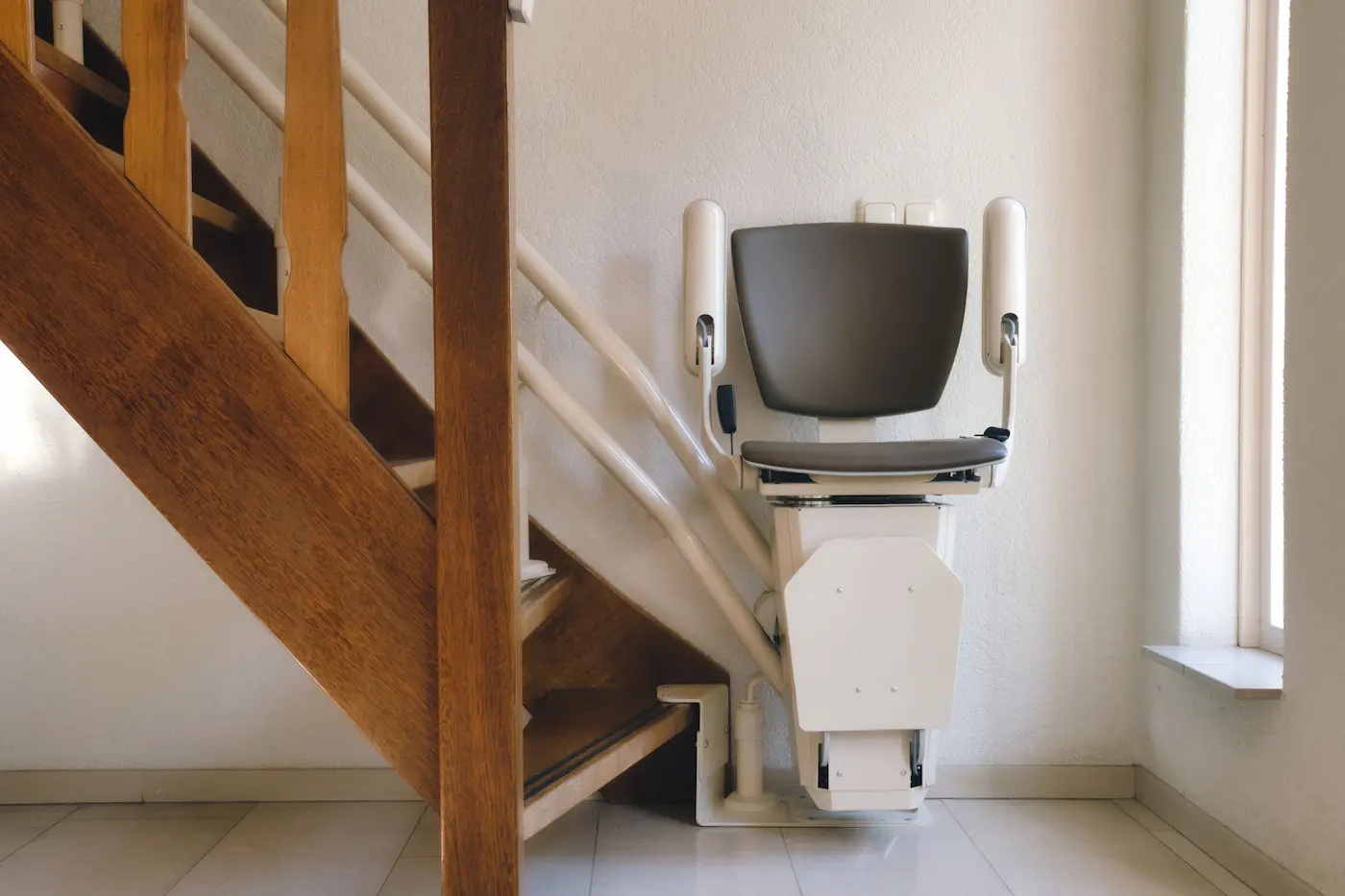 Silla salvaescaleras plegada contra el raíl en una escalera de una vivienda de Majadahonda